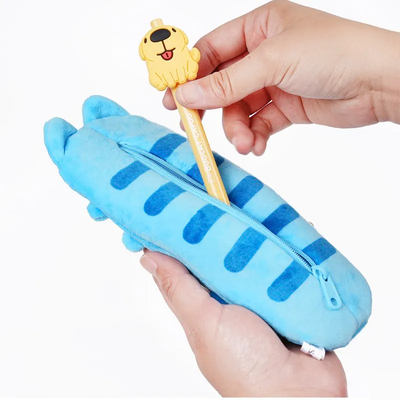 A person putting a pen into Capoo Flat Pencil Case